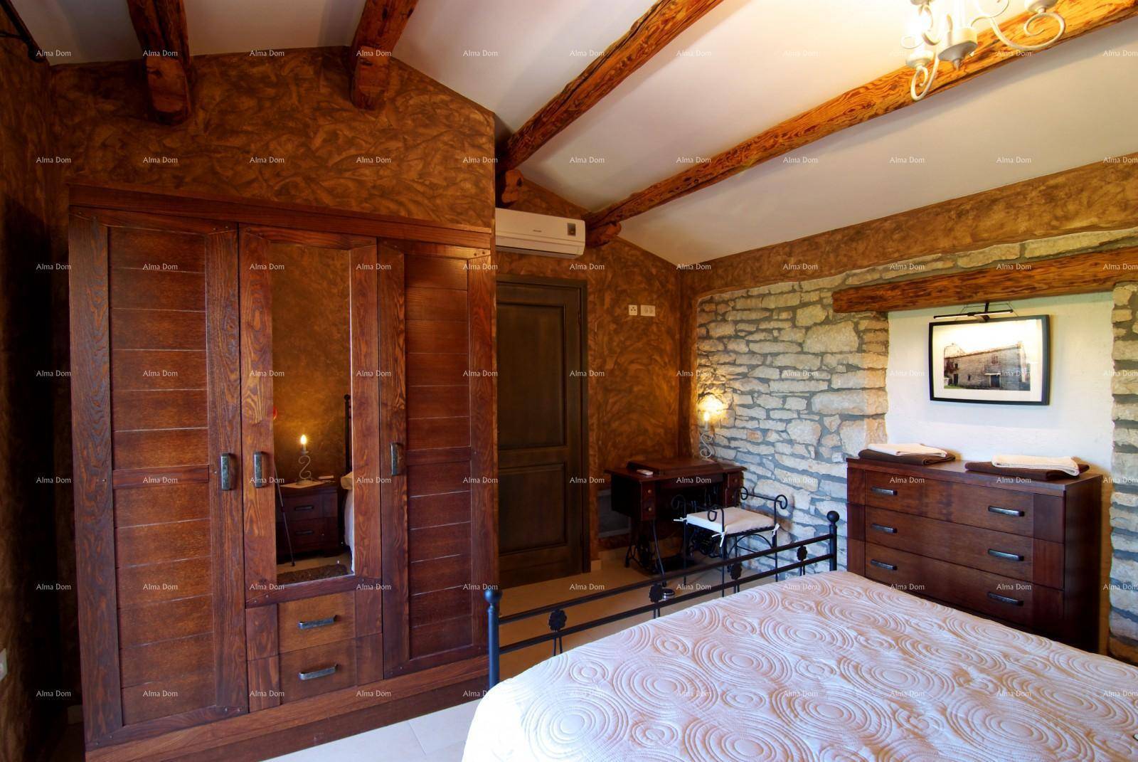 Rustikales Schlafzimmer mit Holzbalken, Steinwand, großem Holzschrank und Klimaanlage.
