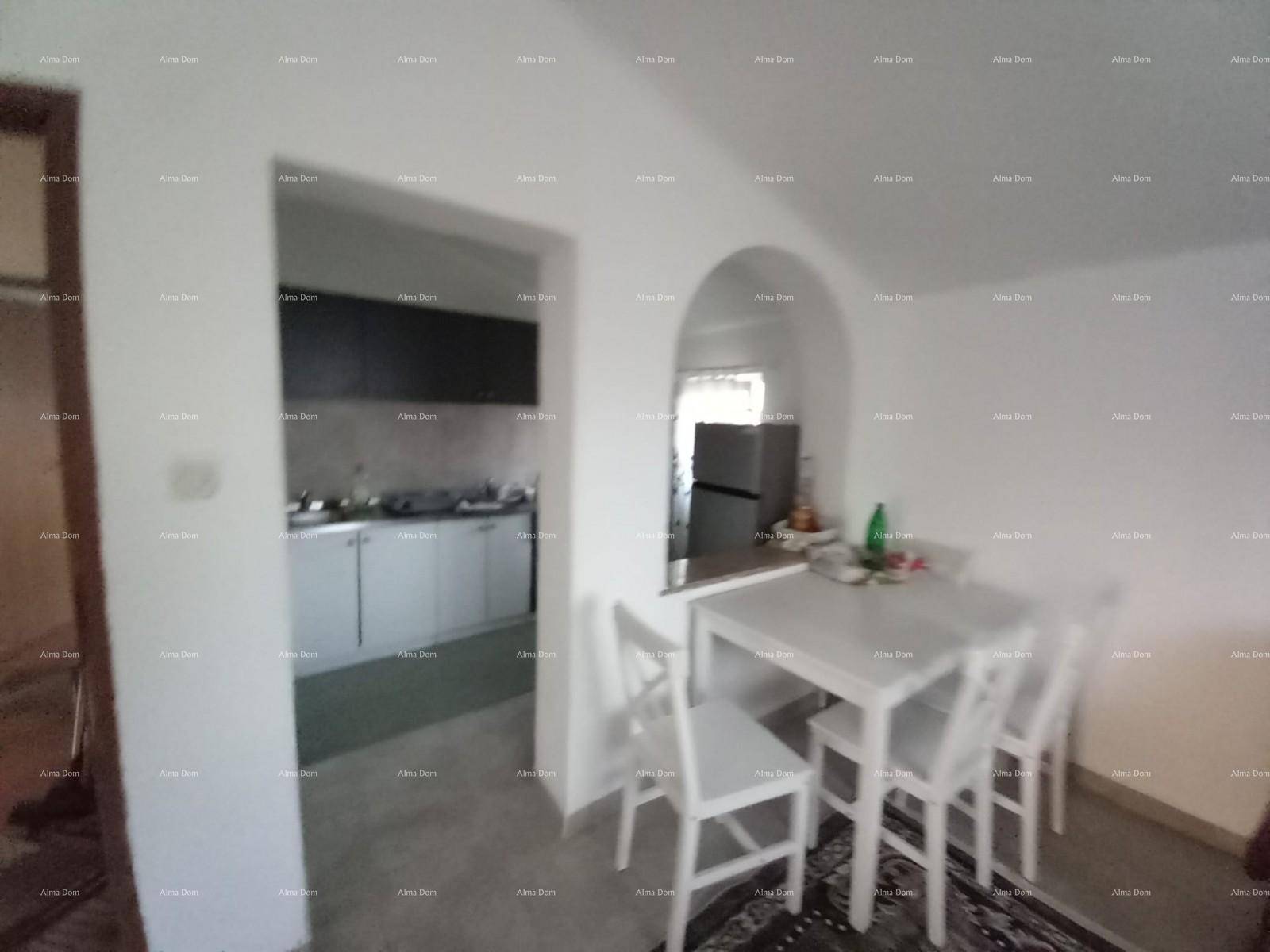 Essbereich mit weißem Tisch und Stühlen, der zu einer separaten Küche führt.