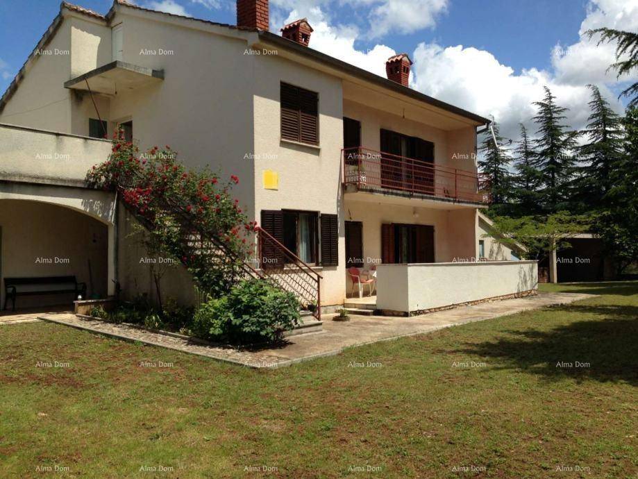 Ansicht des Hauses von außen mit Balkon, Terrasse und gepflegtem Rasenbereich.