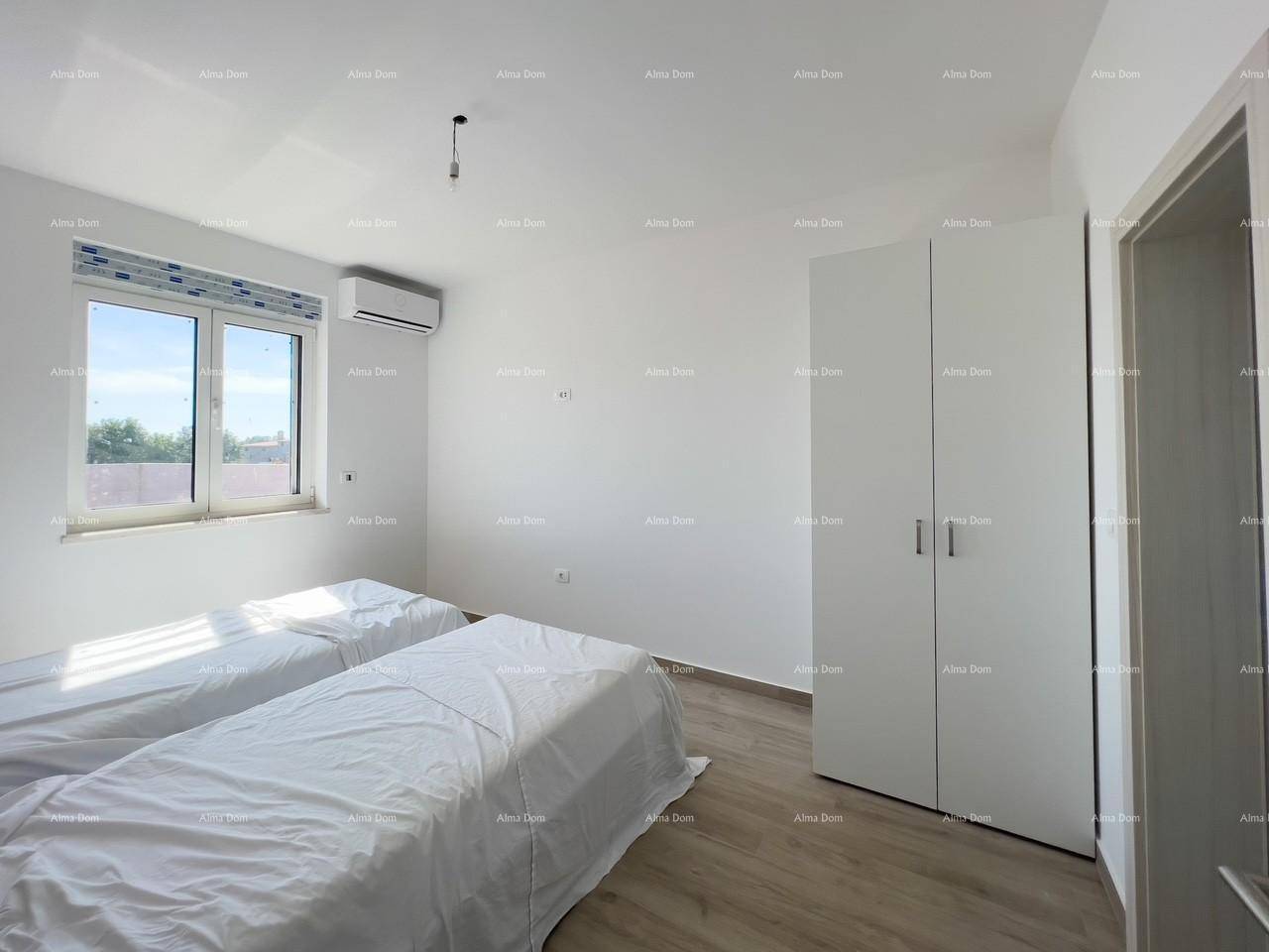 Helles Schlafzimmer mit zwei Einzelbetten, weißem Kleiderschrank und Klimaanlage.
