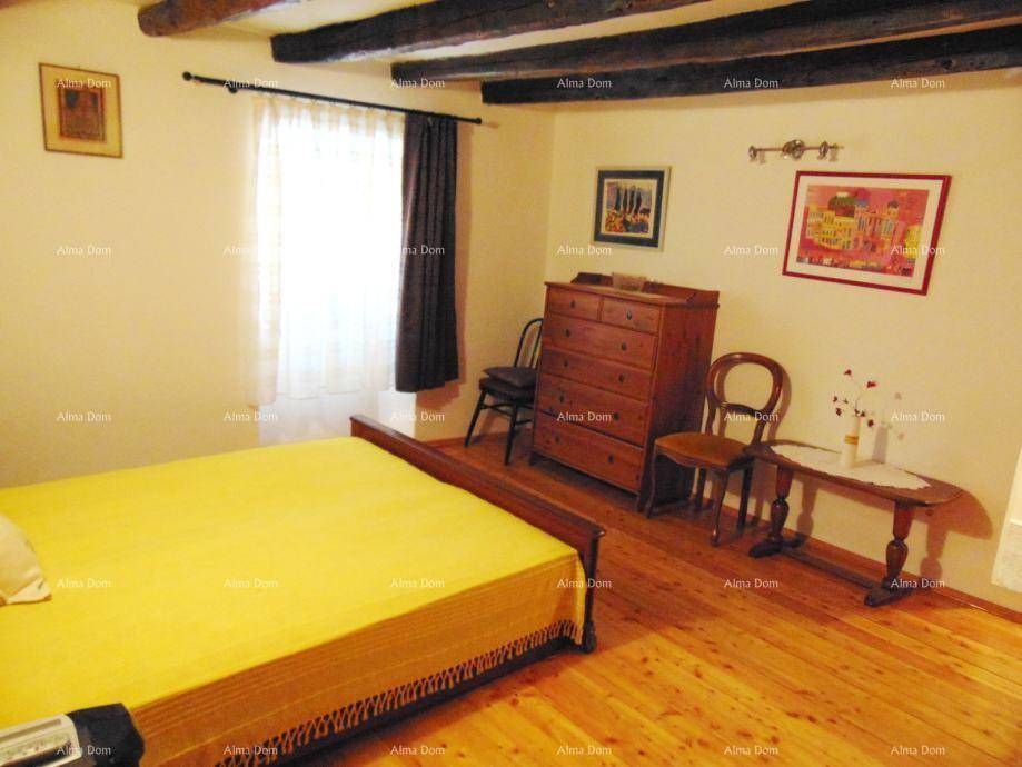 Schlafzimmer mit Holzboden, sichtbaren Deckenbalken und einem gelben Bettüberwurf.