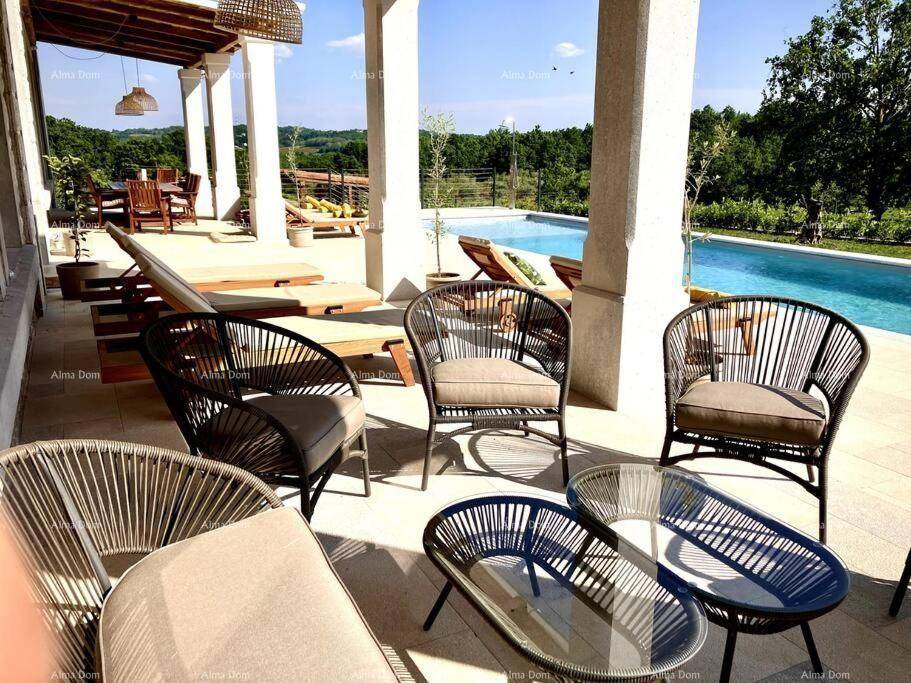 Gemütlicher Lounge-Bereich auf der Terrasse neben dem Pool mit Blick ins Grüne.