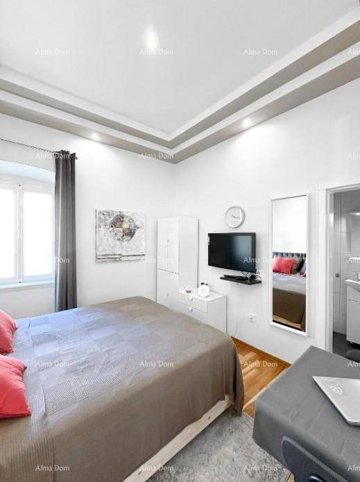 Schlafzimmer mit Fernseher, Schrank und Zugang zu einem weiteren Raum.