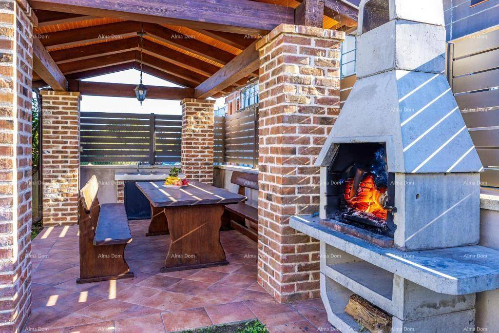 Überdachter Grillbereich mit gemauertem Kamin und rustikalem Holztisch für Mahlzeiten im Freien.