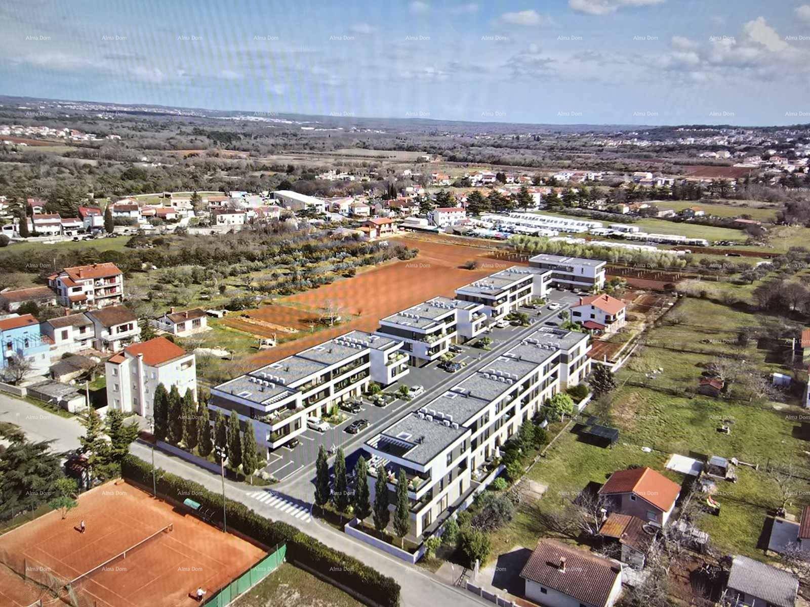 Überblick über moderne Wohngebäude in ländlicher Umgebung mit angrenzenden Feldern und einem Tennisplatz.