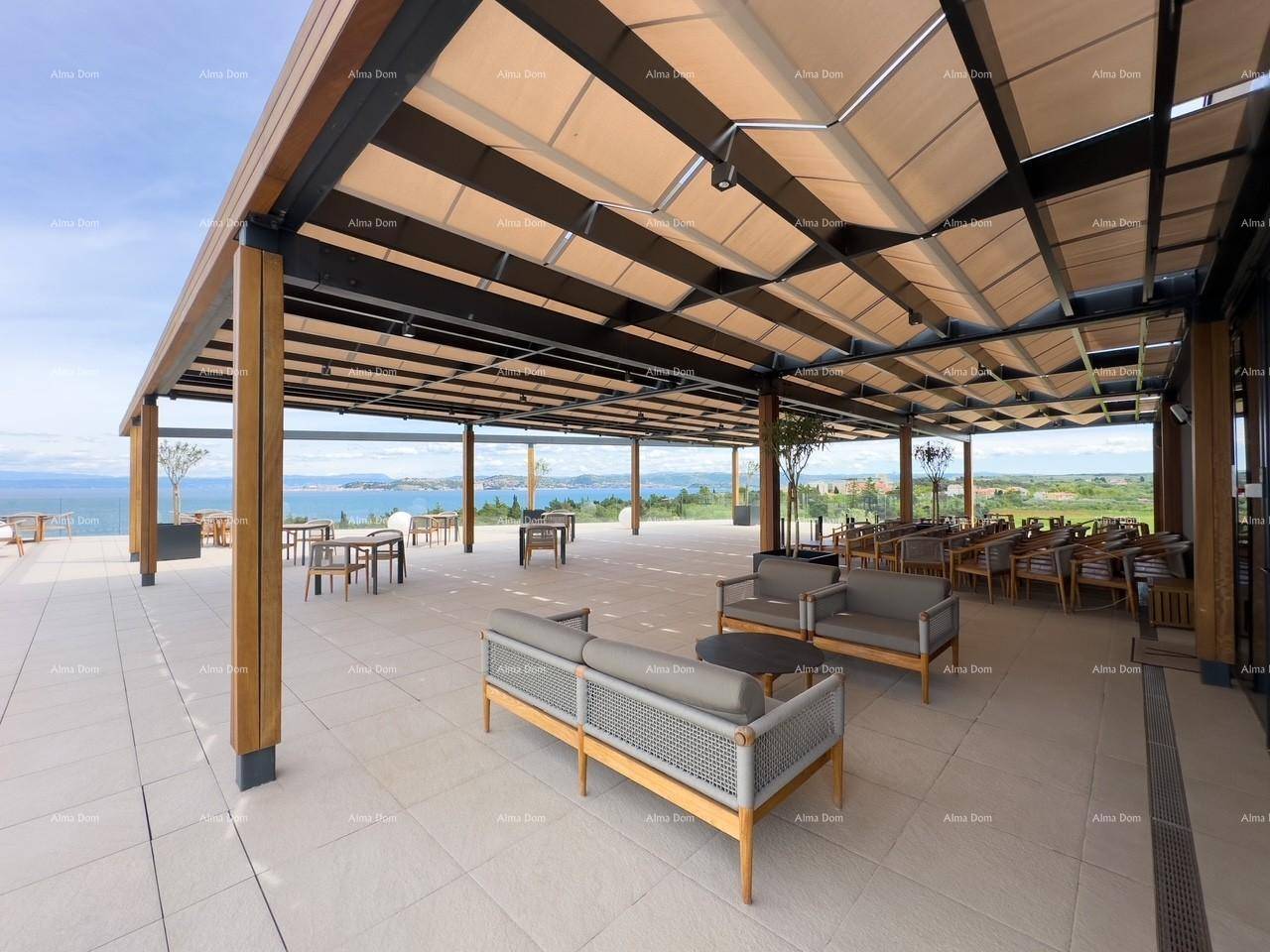 Elegante Außenterrasse mit vielfältigen Sitzgelegenheiten unter einer Pergola, die einen weiten Blick auf das Meer bietet.