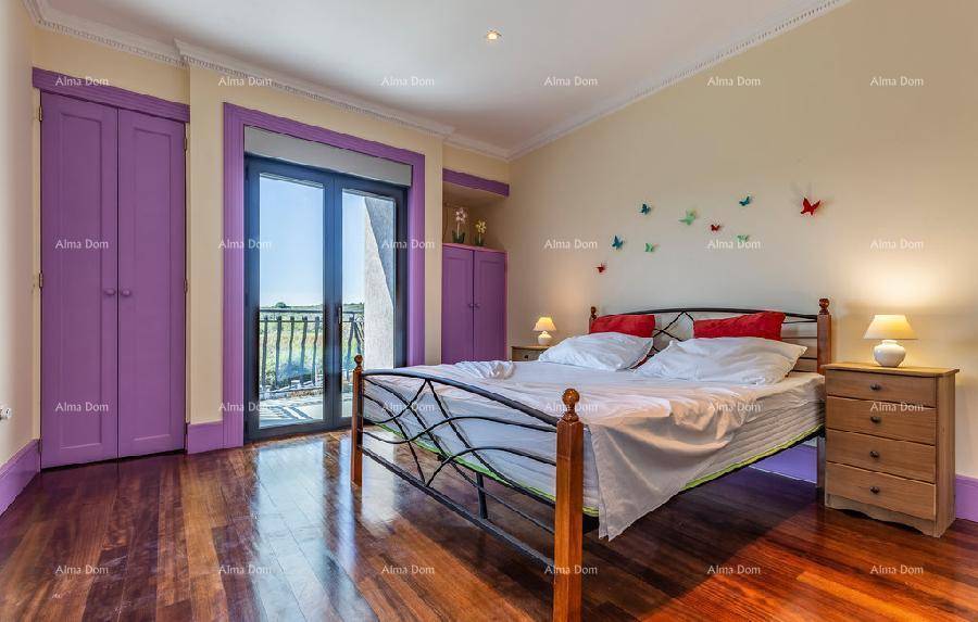 Schlafzimmer mit Doppelbett, Holzboden, lila Schränken und Balkonzugang.