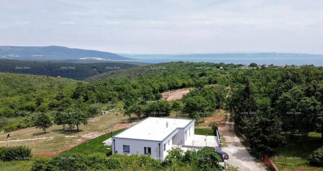 Luftaufnahme der modernen Villa in grüner Umgebung mit Fernblick auf das Meer.