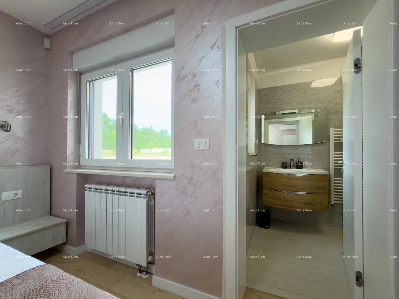 Schlafzimmer mit Fenster und Blick in das angrenzende moderne Badezimmer.