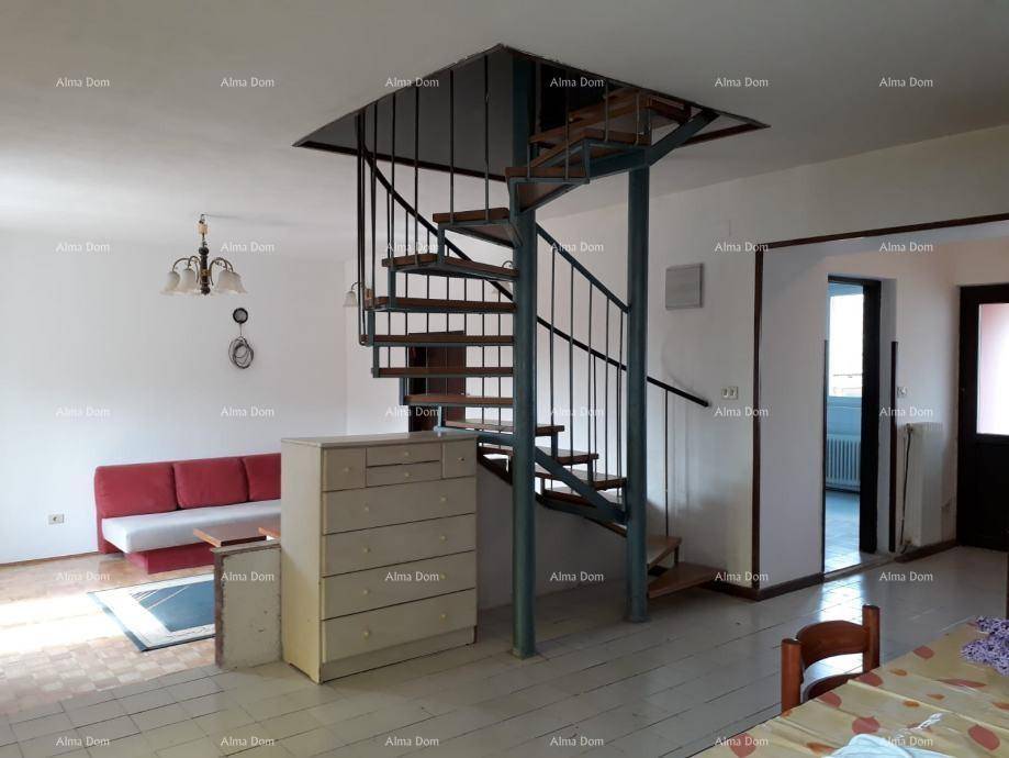 Heller Wohnbereich mit einer Wendeltreppe, Sofa und Parkettboden.