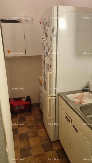 Küchenbereich mit einem Kühlschrank, einer Spüle und praktischen Oberschränken für zusätzlichen Stauraum.