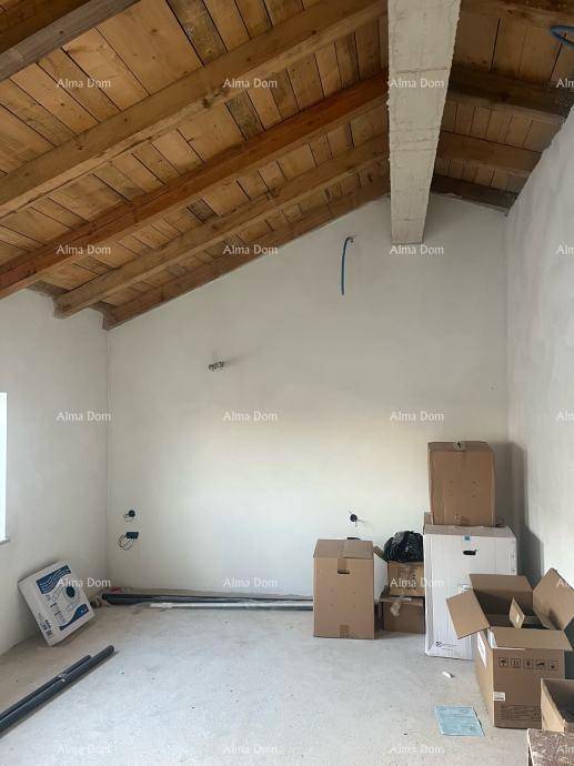 Geräumiger Rohbau-Innenraum mit Holzbalkendecke und Kartons, bereit für den Ausbau.