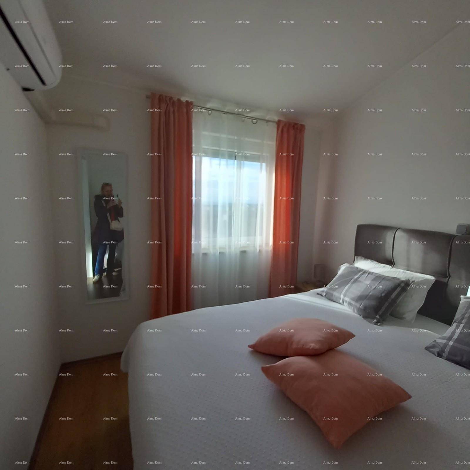 Helles Schlafzimmer mit Doppelbett, rosafarbenen Vorhängen und Klimaanlage.