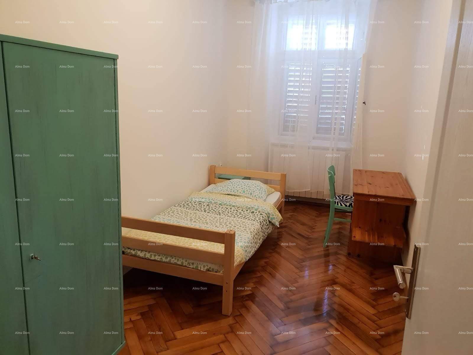 Schlafzimmer mit Einzelbett, Holzschrank und Fischgrätparkettboden, ideal für Gäste oder Kinder.