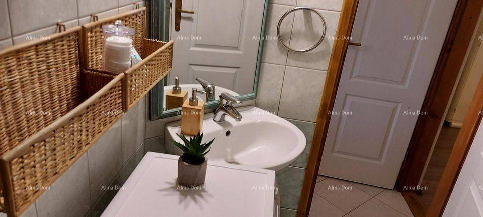 Kleines Badezimmer mit Waschbecken, Spiegel und gefliesten Wänden.