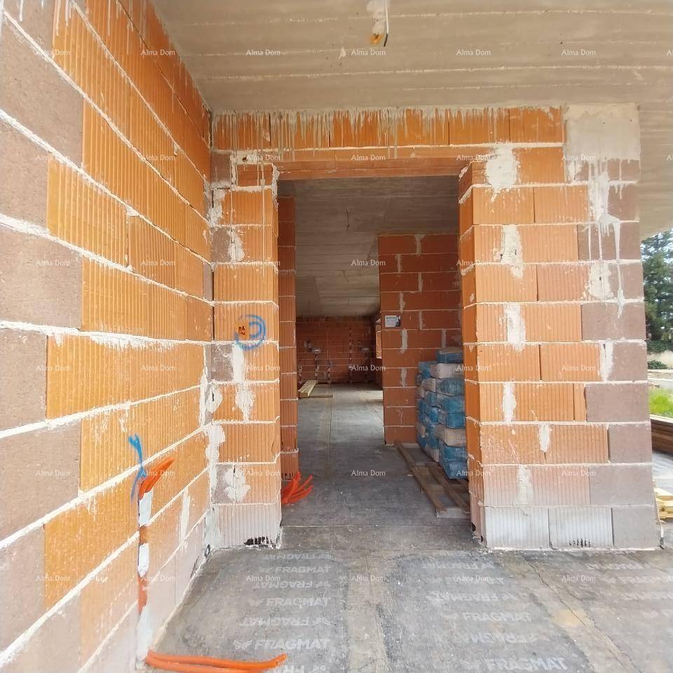 Innenansicht eines Raumes im Rohbau mit Ziegelwänden und Betonboden, bereit für den weiteren Ausbau.