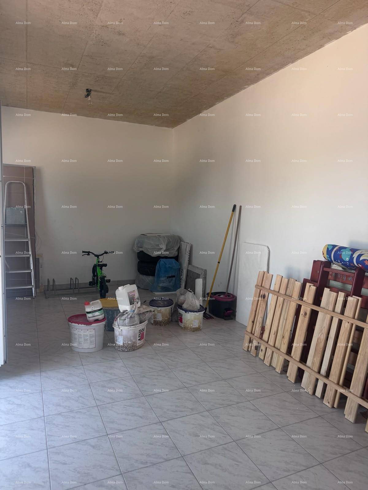 Lagerraum mit Fliesenboden, Beton-Decke und verschiedenen Baumaterialien und Werkzeugen.