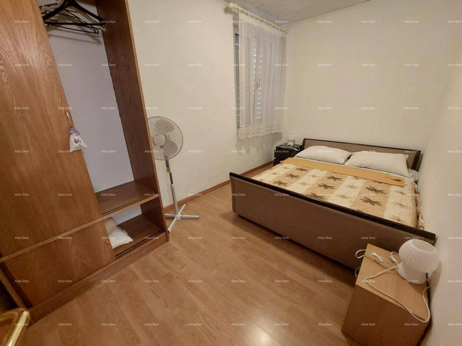 Zweites Schlafzimmer mit Einzelbett, Holzschrank und Ventilator.