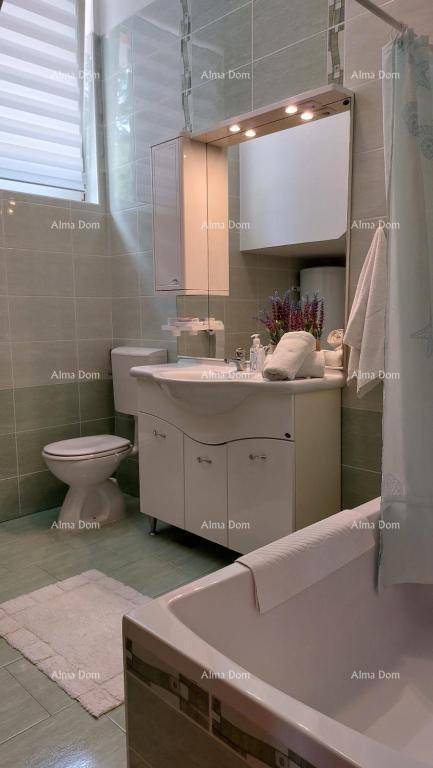 Modernes Badezimmer mit Badewanne, WC, Waschbecken und Spiegelschrank.