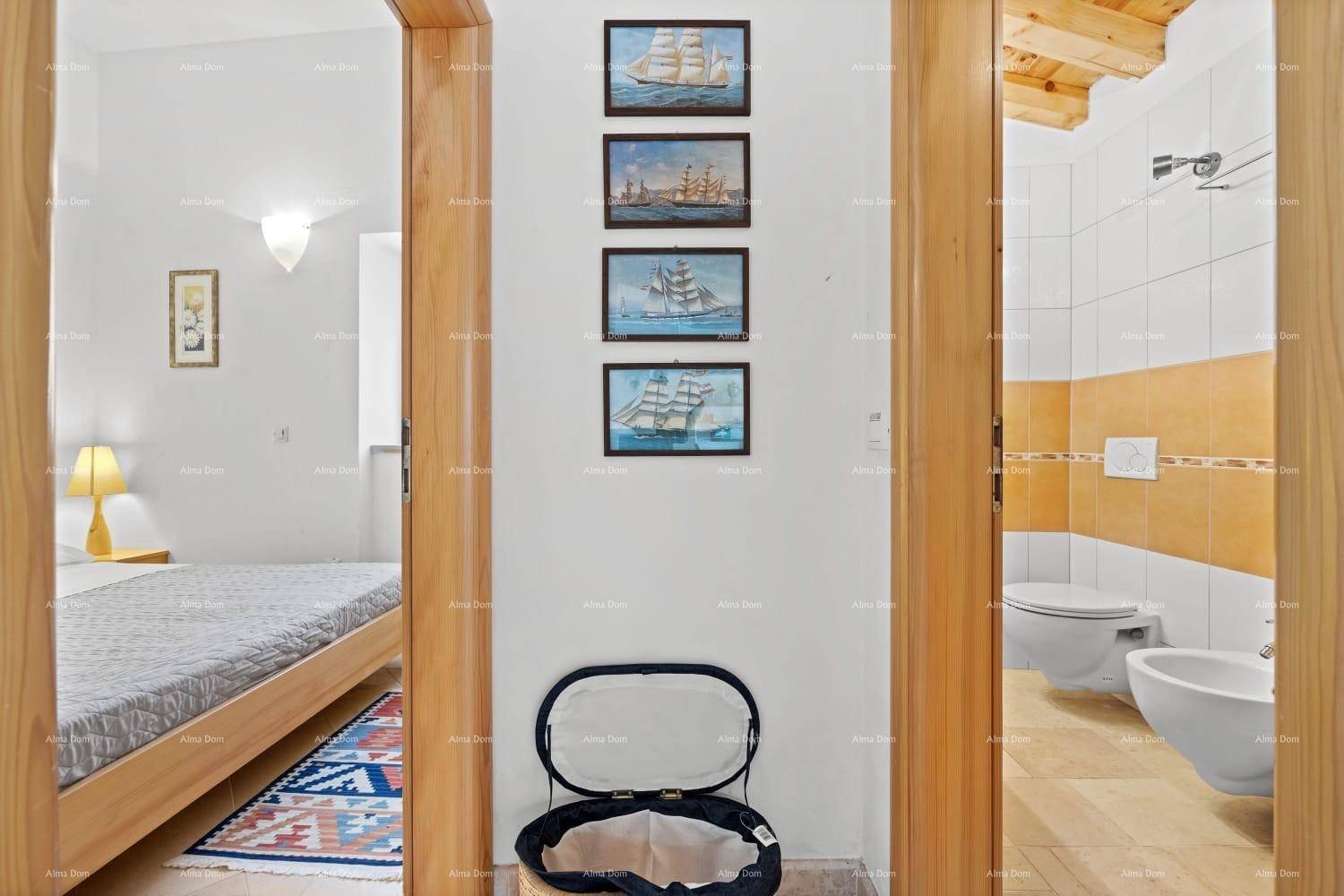Flur verbindet Schlafzimmer und Badezimmer, dekoriert mit maritimen Bildern an der Wand.