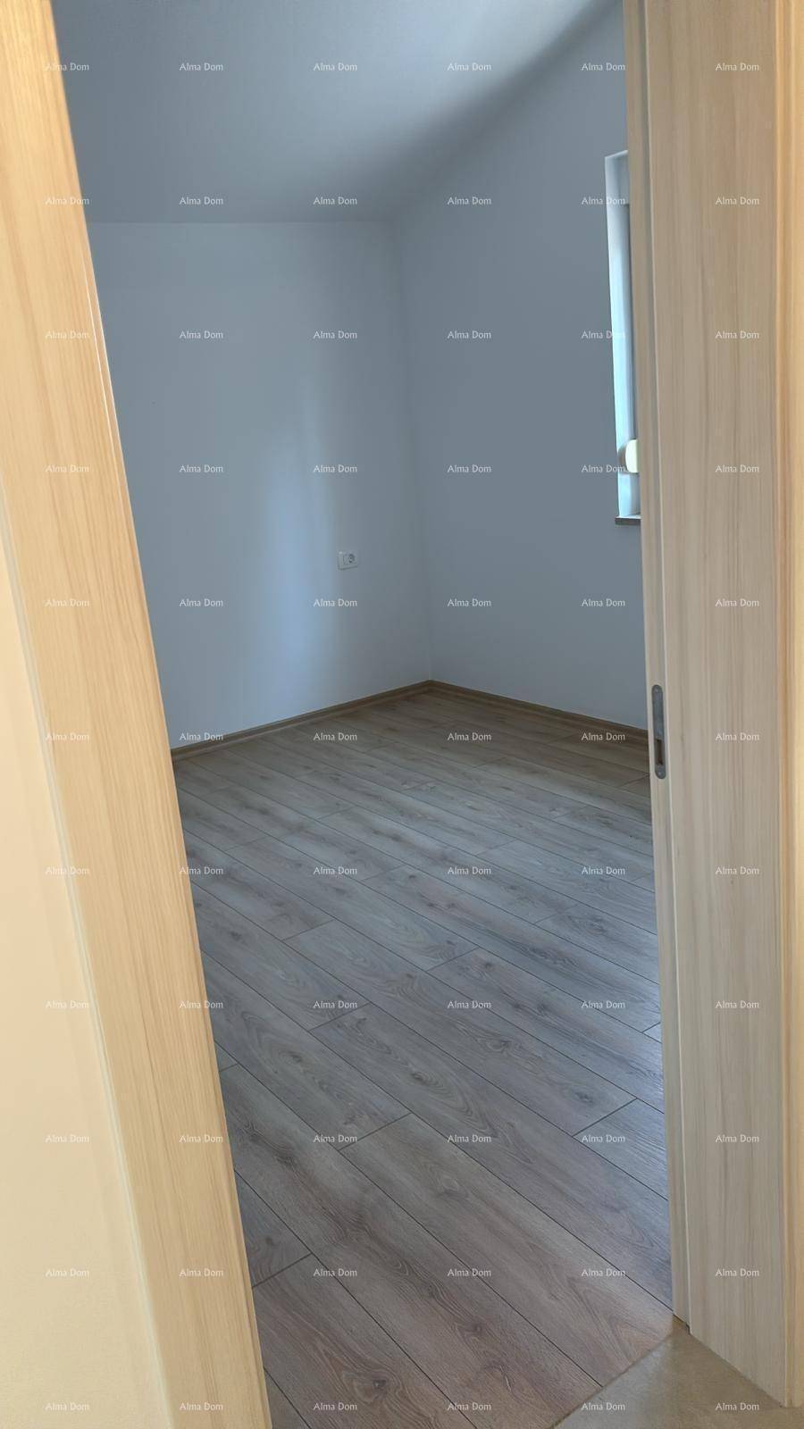Leeres Zimmer mit hellem Laminatboden und einem Fenster, bereit zur individuellen Gestaltung.