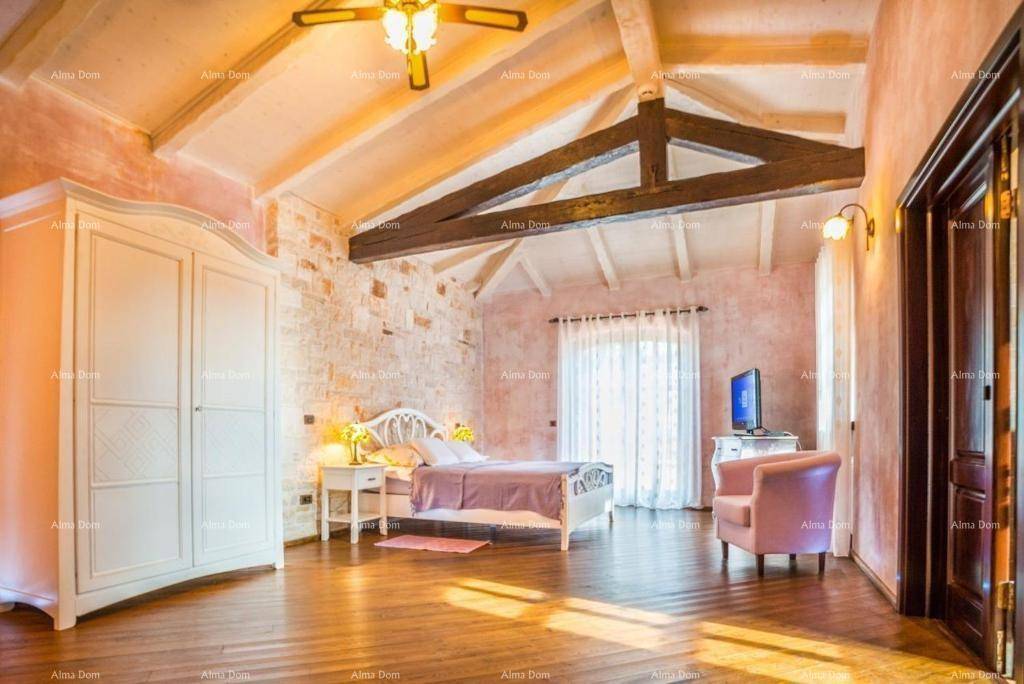 Charmantes Schlafzimmer mit gewölbter Decke, Holzboden und einer Steinwand in warmen Rosatönen.