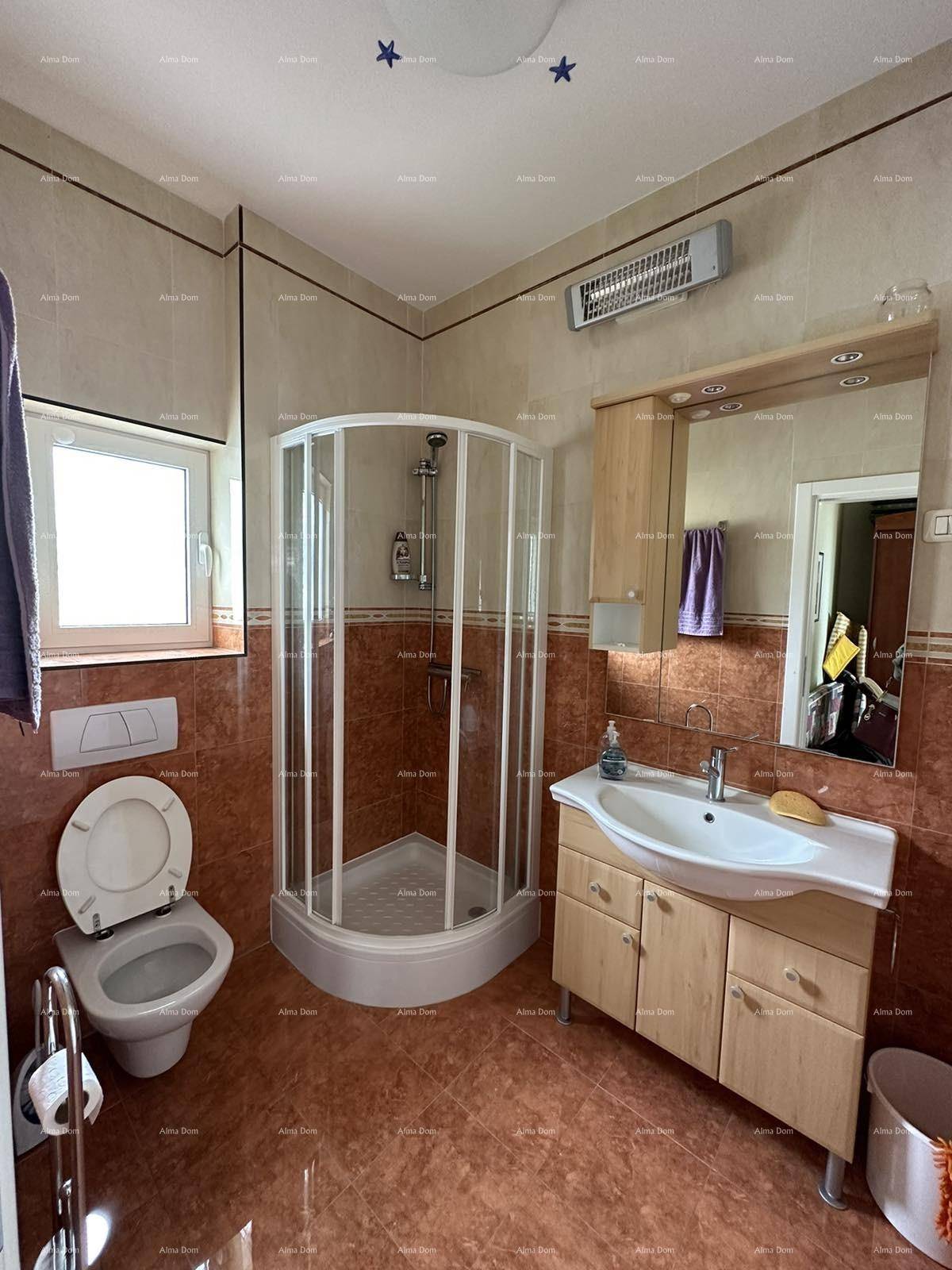 Badezimmer mit Duschkabine, WC, Waschbecken und braunen Fliesen an Wänden und Boden.