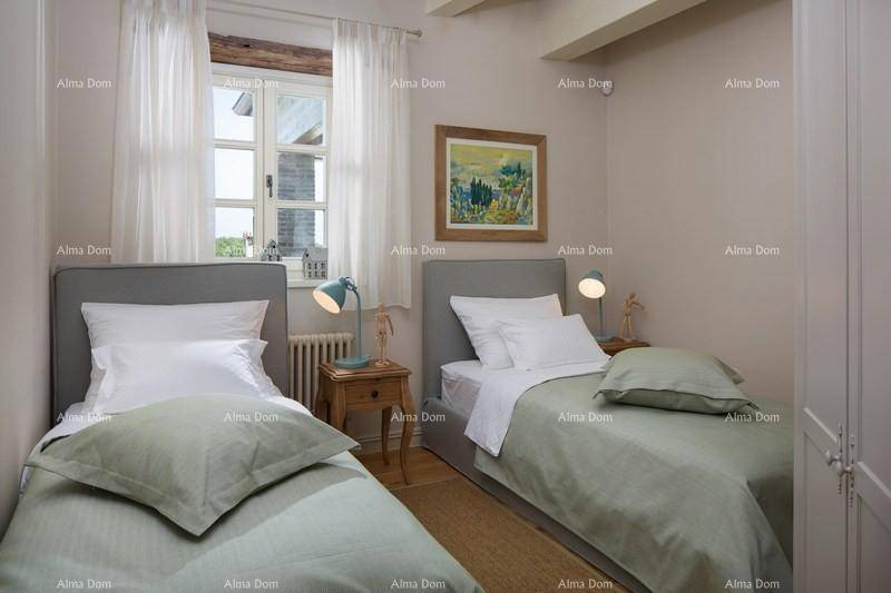 Helles Schlafzimmer mit zwei Einzelbetten, Holzboden und Blick aus dem Fenster.