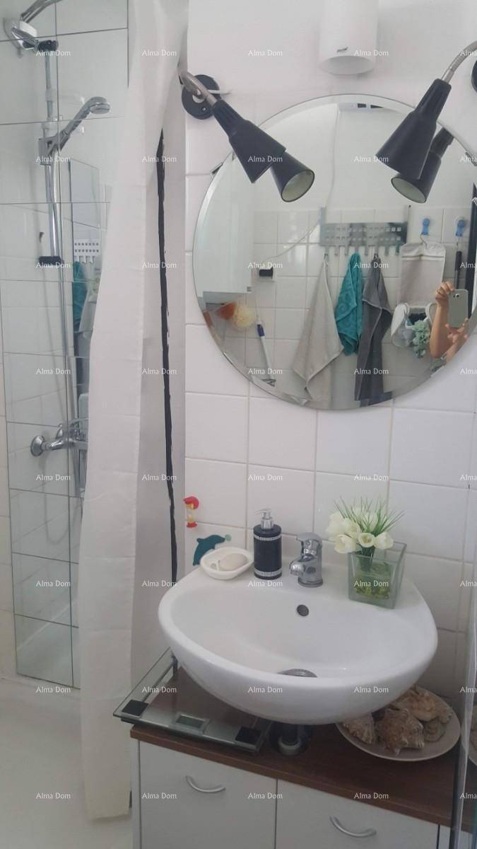 Helles Badezimmer mit Dusche, modernem Waschbecken und rundem Spiegel.
