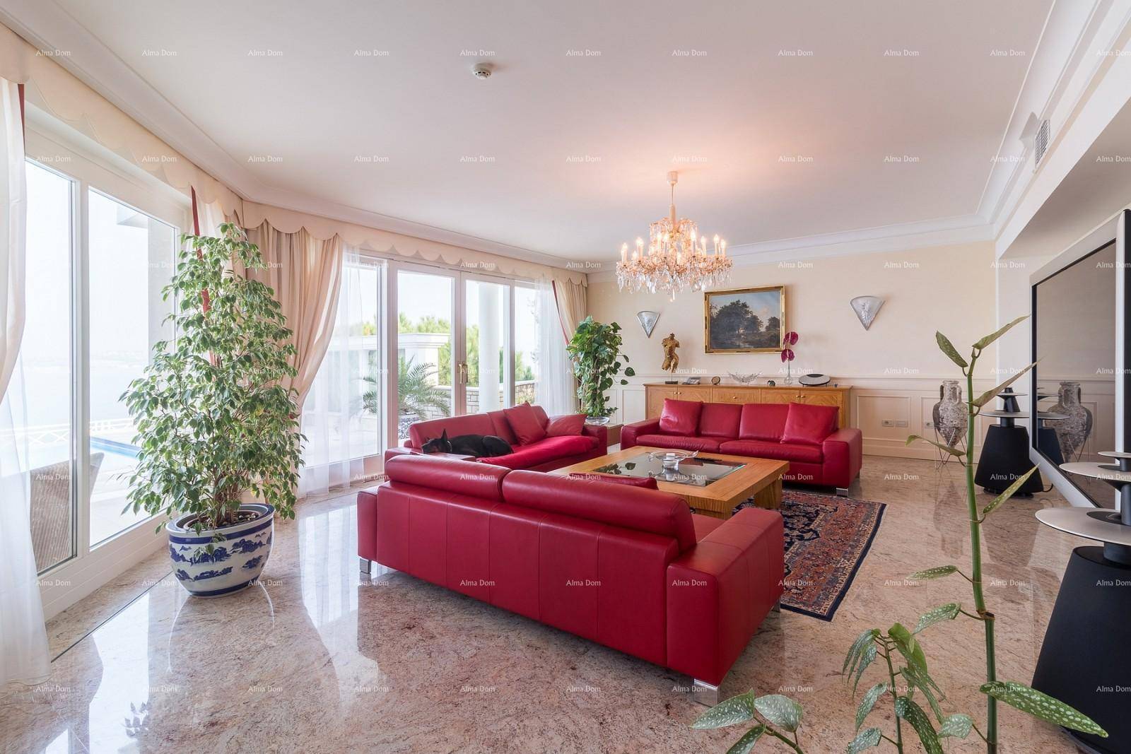 Geräumiges Wohnzimmer mit roten Ledersofas, Marmorboden und Zugang zur Terrasse mit Poolblick.