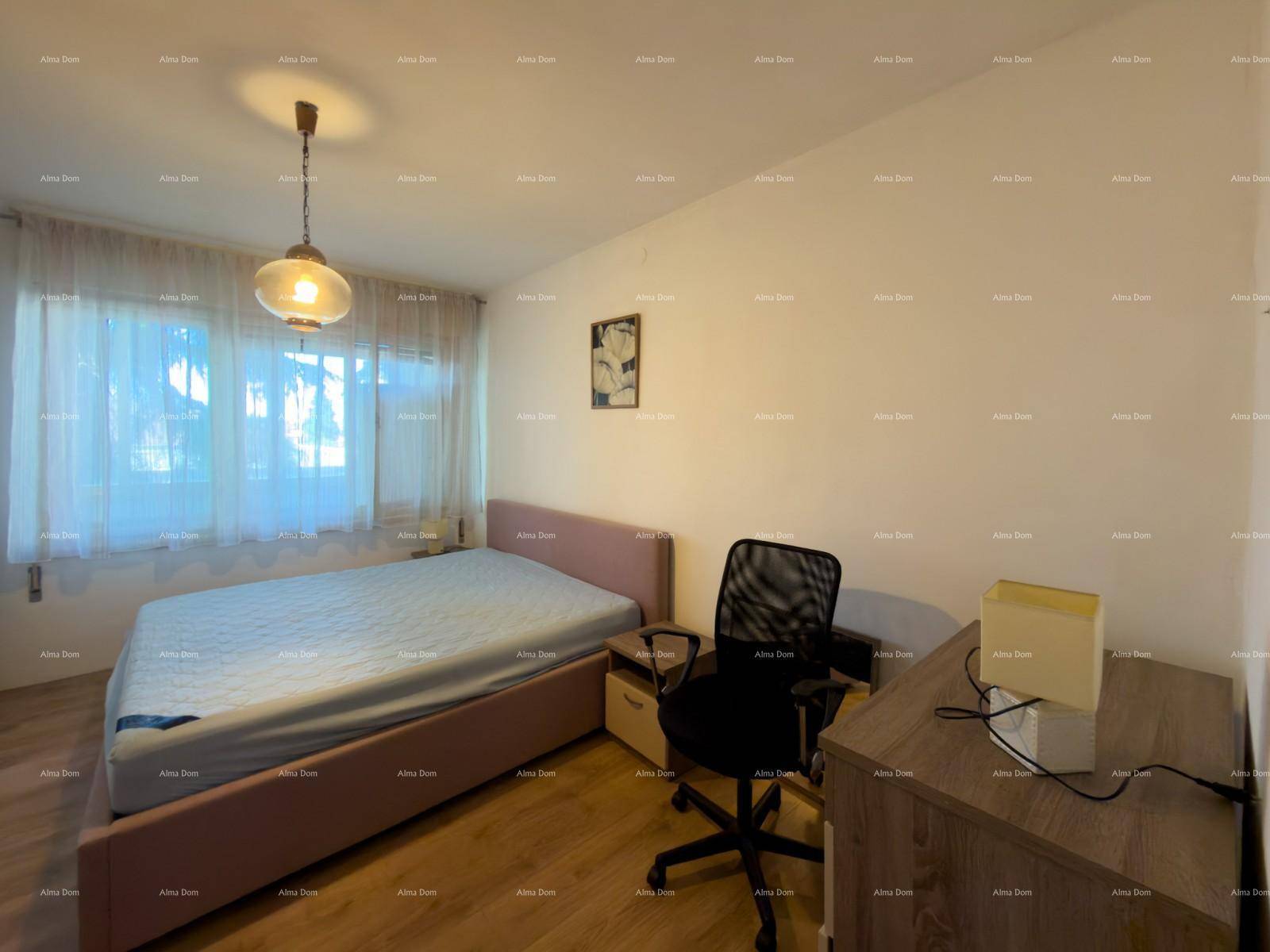 Schlafzimmer mit Doppelbett, Schreibtisch und Holzfußboden.