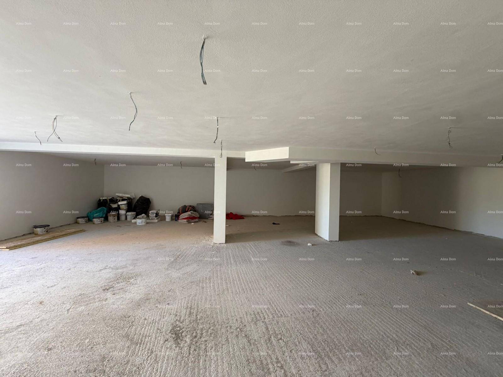 Weiter Blick in einen großen, unfertigen Kellerraum mit Säulen und Betonboden.