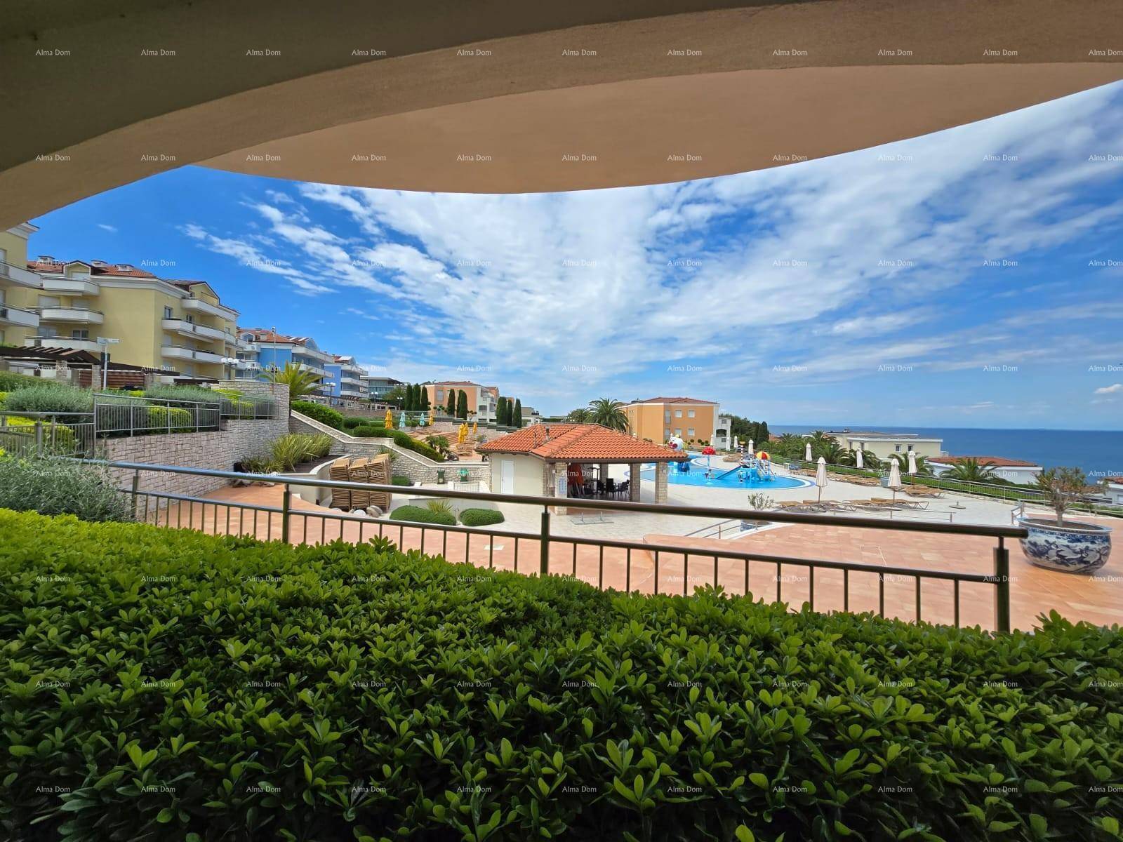 Panoramablick auf die Wohnanlage mit Poolbereich, Terrassen und dem Meer im Hintergrund.