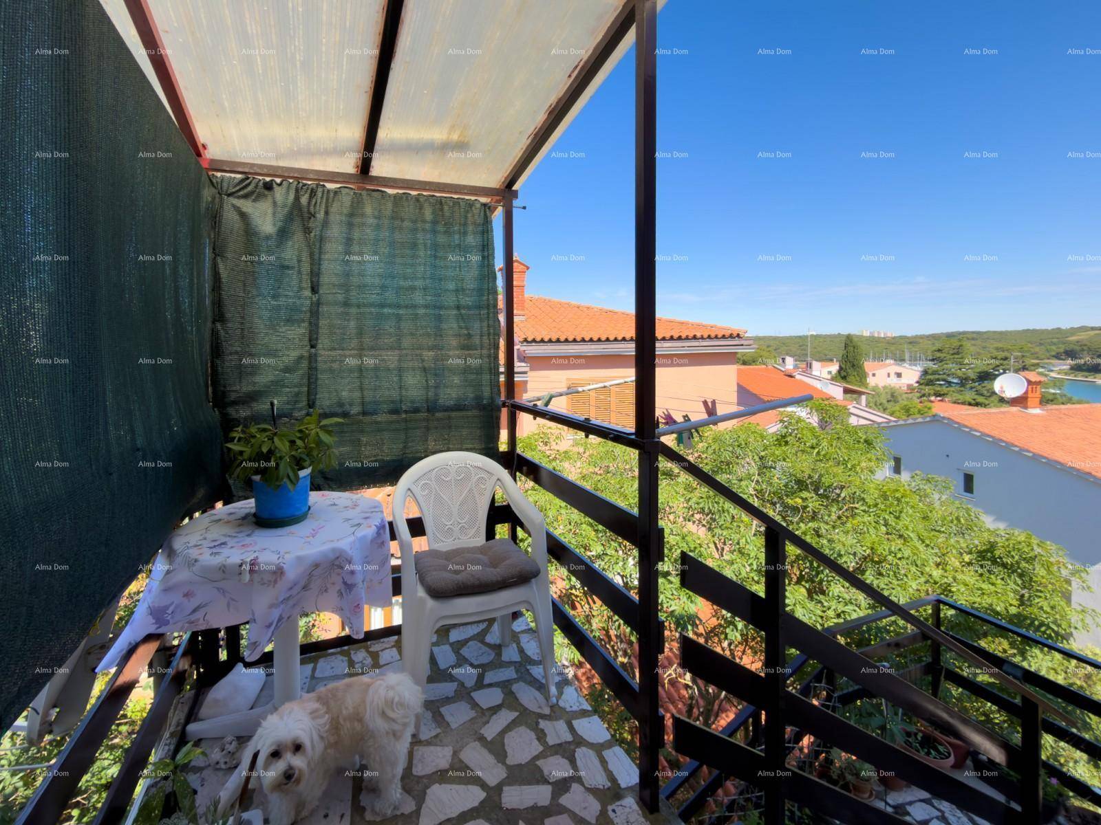 Kleiner Balkon mit Tisch und Stuhl, ideal für entspannte Momente im Freien mit Blick ins Grüne.