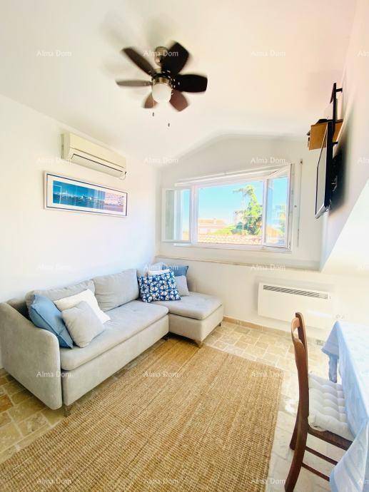 Gemütlicher Wohnbereich mit Ecksofa, Deckenventilator und Klimaanlage, angrenzend an einen Essbereich.