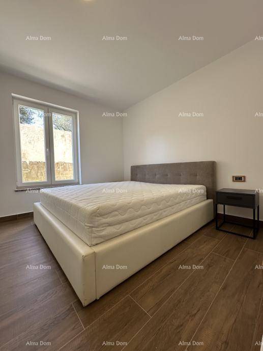 Helles Schlafzimmer mit Doppelbett, Nachttisch und großen Fenstern.