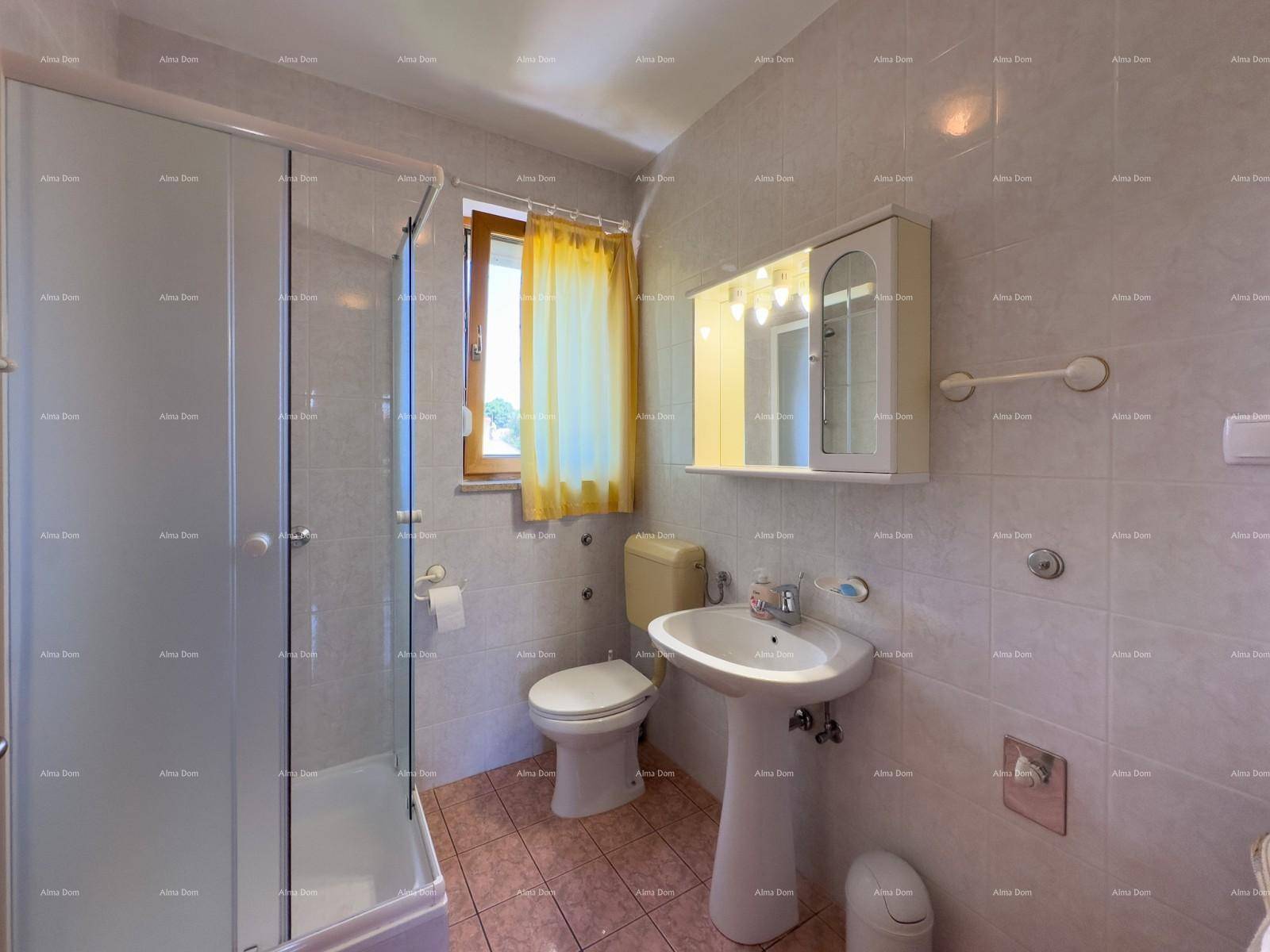 Badezimmer mit Duschkabine, WC, Waschbecken und Spiegelschrank.