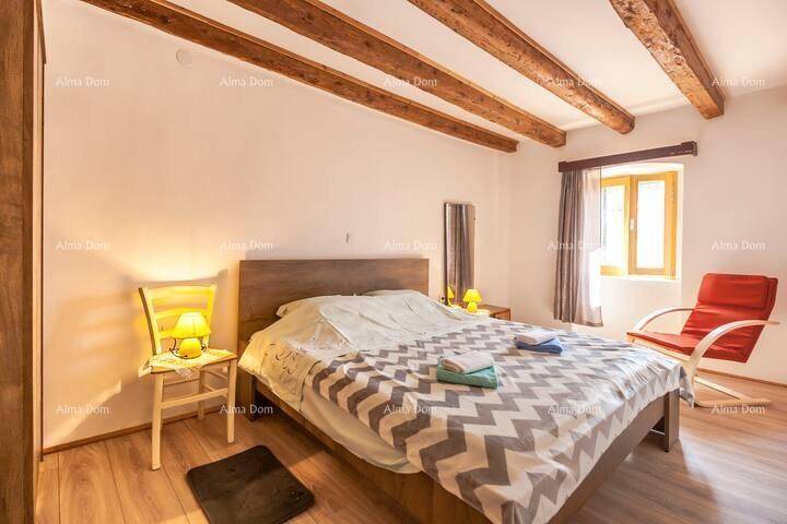 Schlafzimmer mit Doppelbett, Holzbalkendecke und Holzboden, hell und einladend.