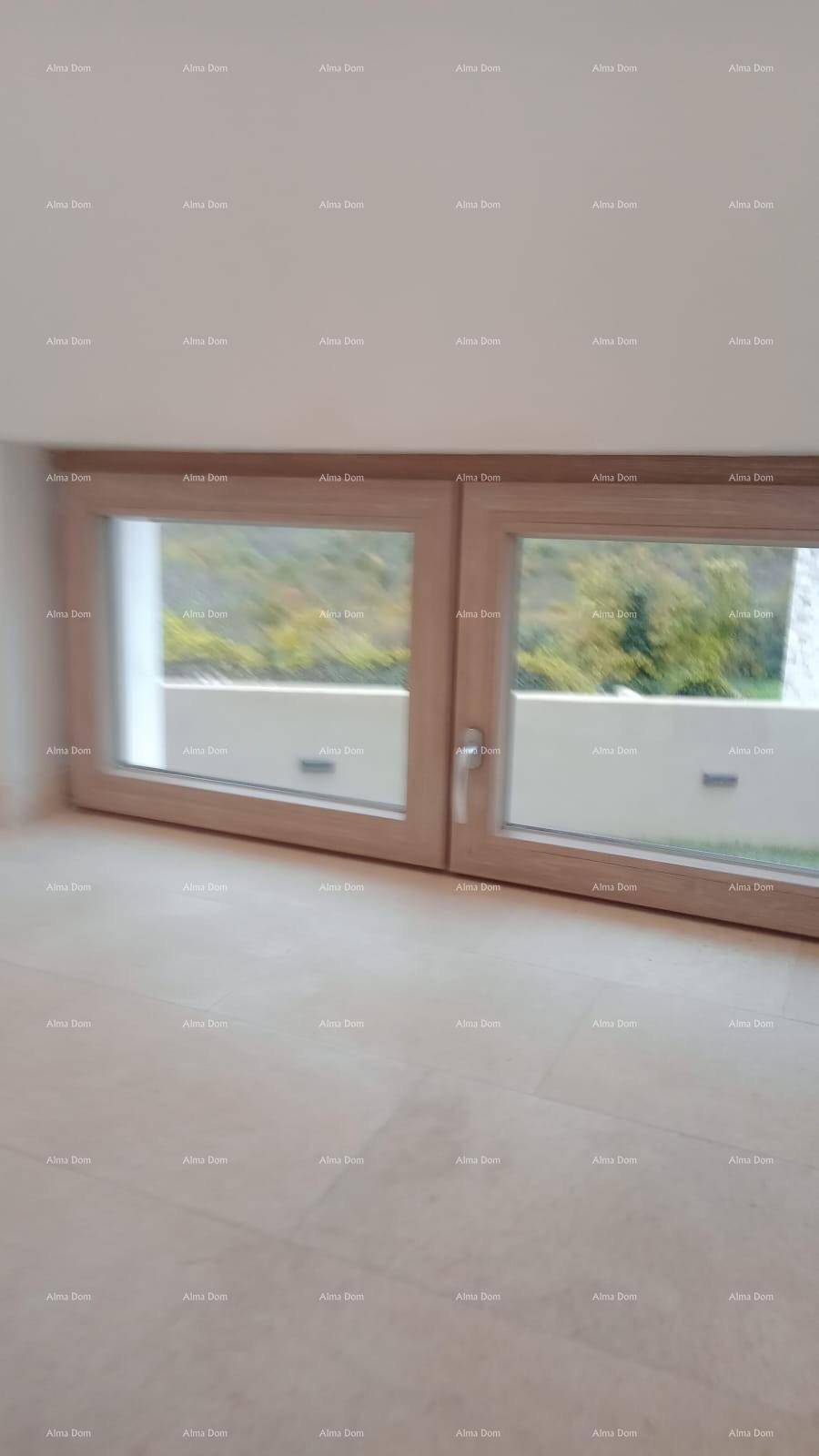 Zwei bodennahe Fenster mit Blick ins Grüne, die viel Tageslicht in den Raum lassen.