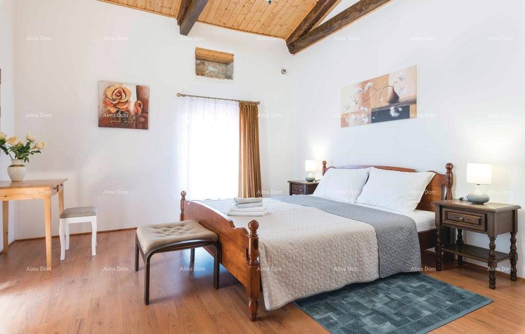 Geräumiges Schlafzimmer mit Holzbalkendecke, Doppelbett und Holzboden.
