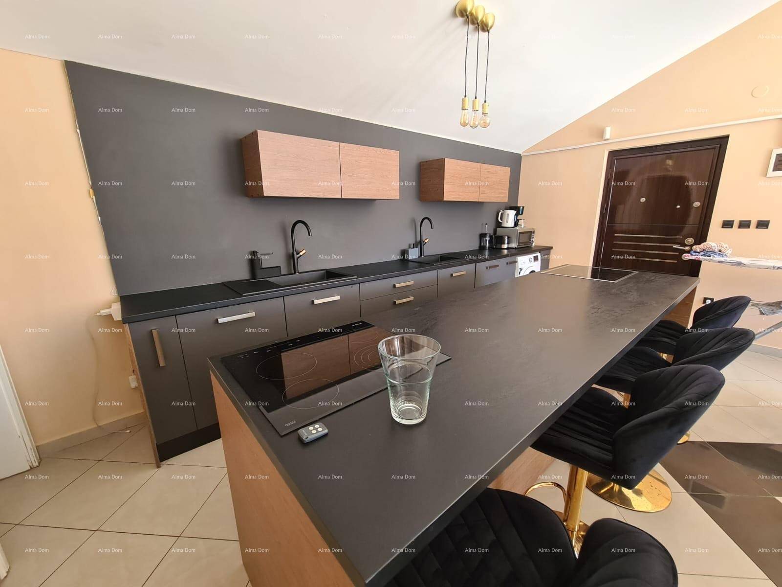 Moderne Küche mit Kücheninsel, Barhockern und dunklen Arbeitsplatten.