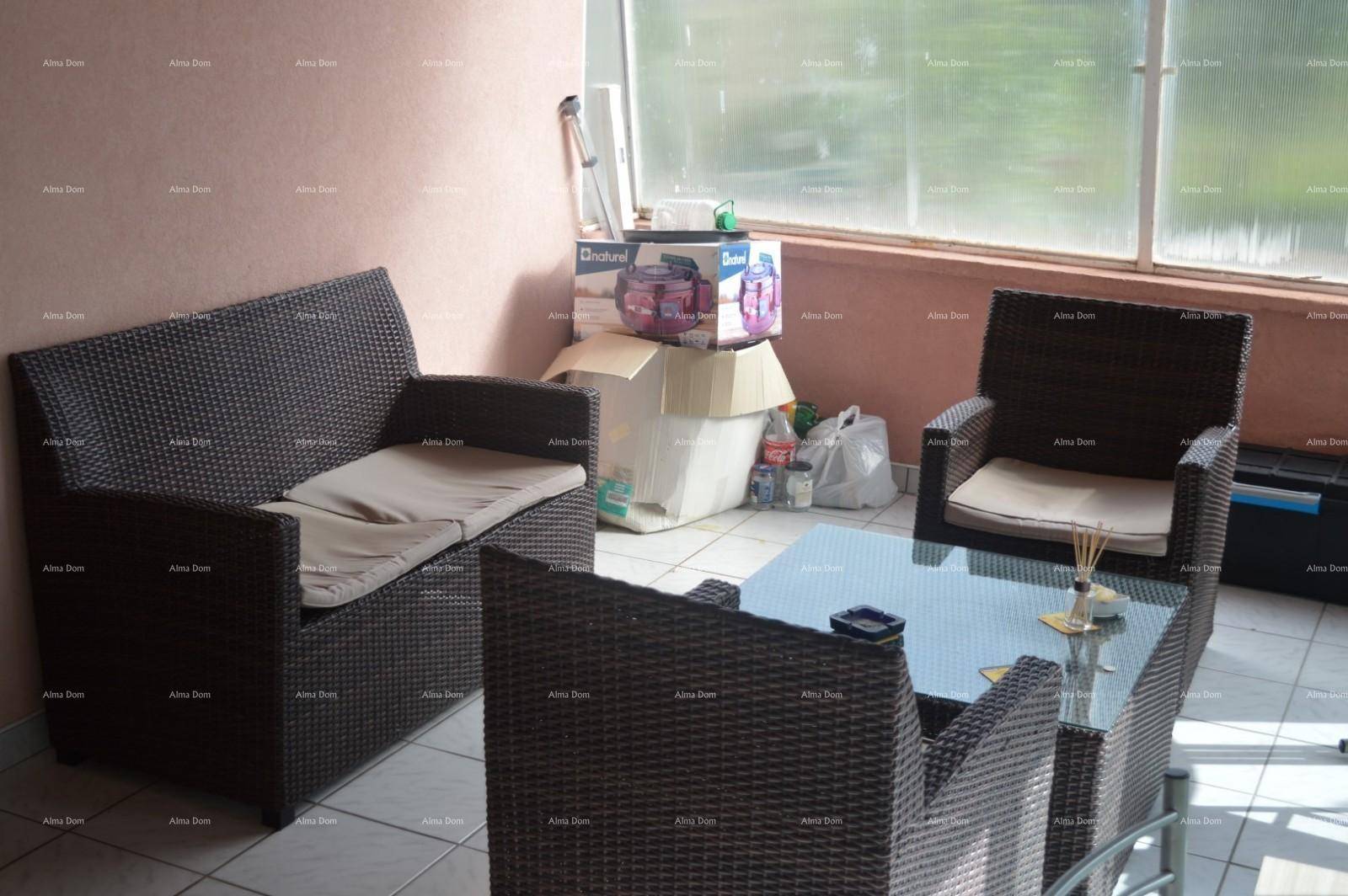 Verglaster Wintergarten mit Rattanmöbeln und Blick ins Grüne, genutzt als Entspannungsbereich.