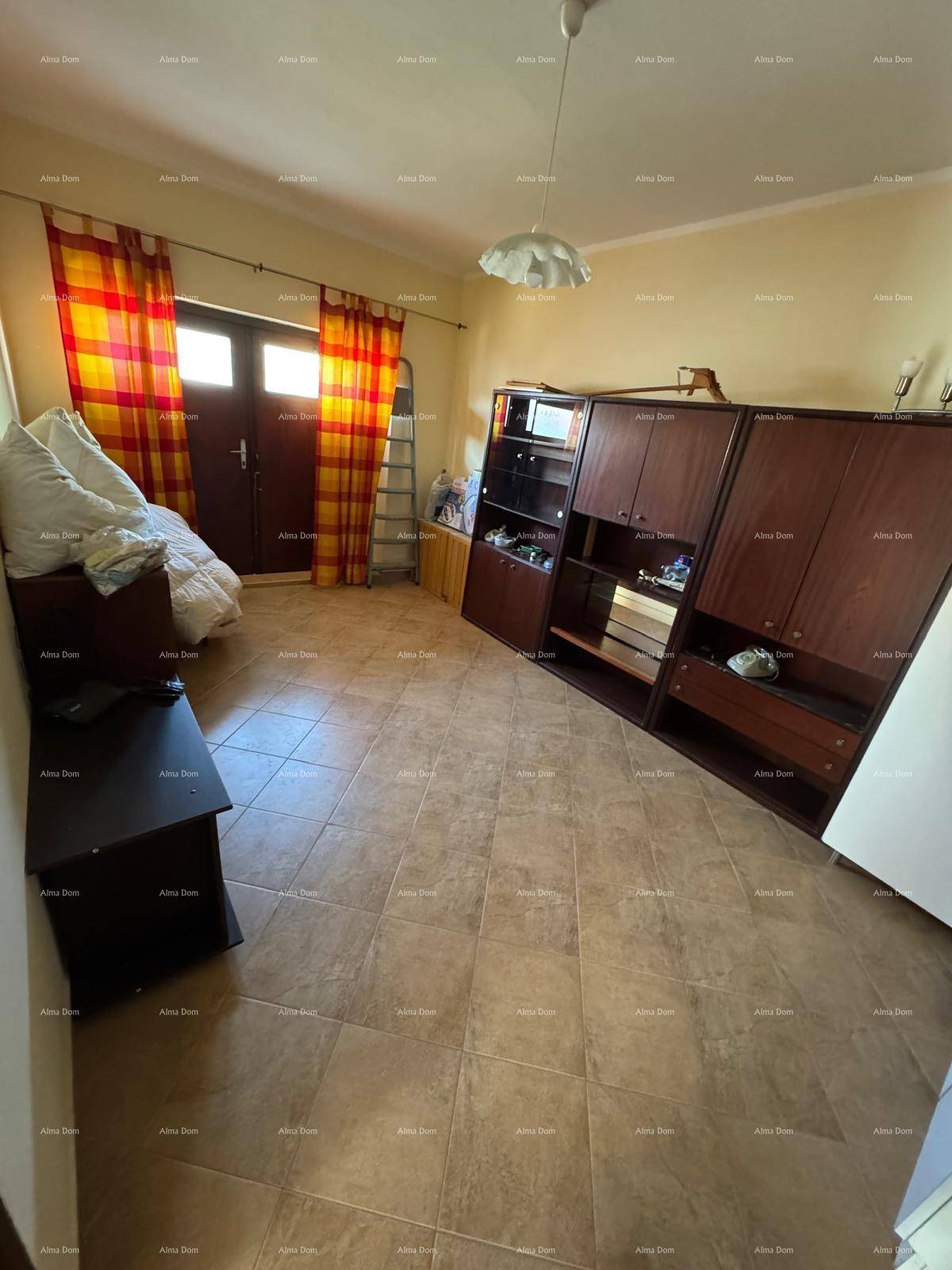 Schlafzimmer mit großem Kleiderschrank, Fliesenboden und Zugang zu einem Balkon.