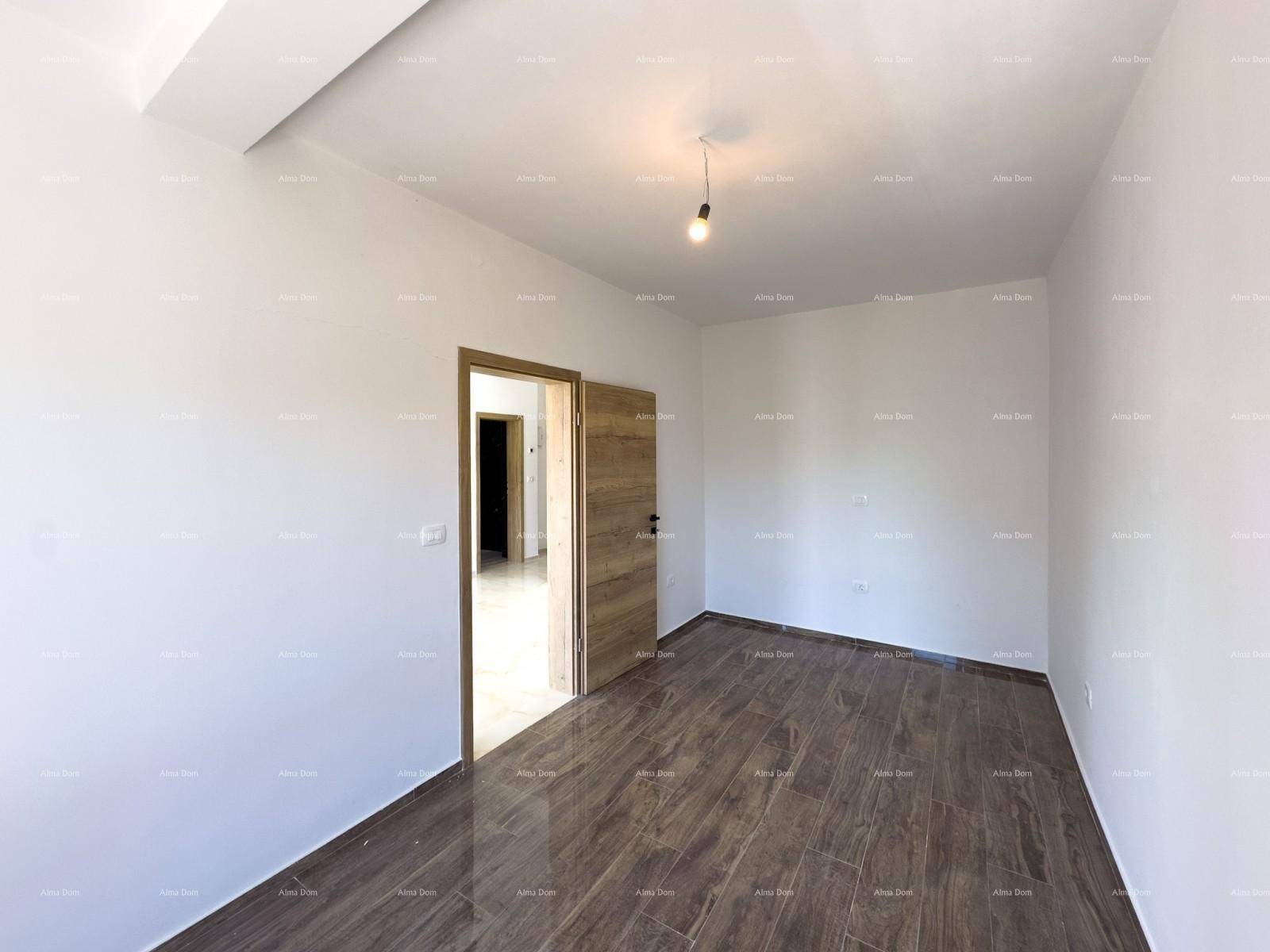 Helles Schlafzimmer mit dunklem Fliesenboden und einer Holztür, die zu einem weiteren Raum führt.