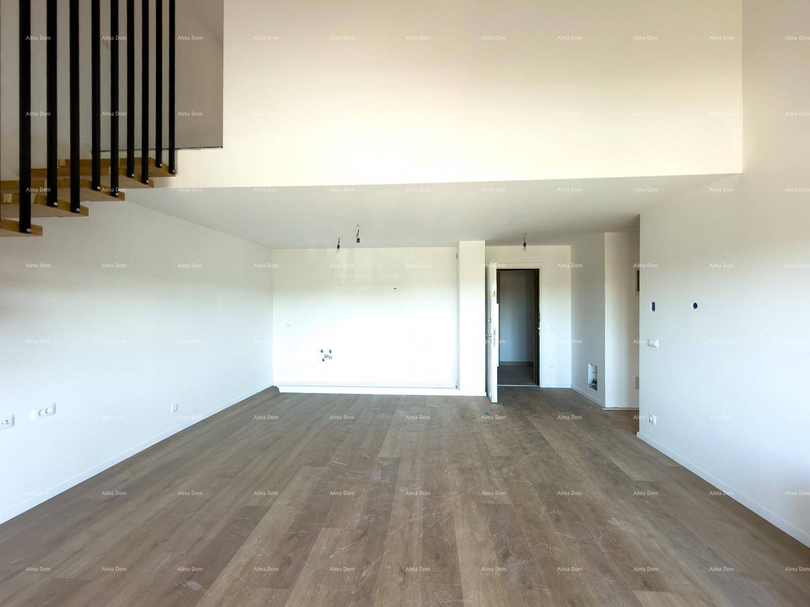 Großer, leerer Wohnraum mit hellem Holzboden und der modernen Treppe als architektonisches Element.