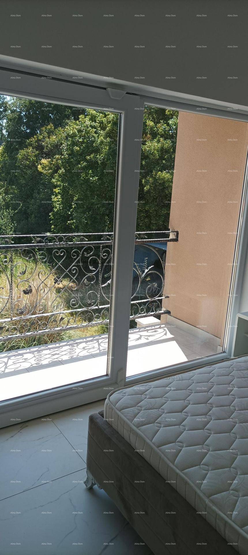 Schlafzimmer mit Bett und großem Fenster, das viel natürliches Licht hereinlässt.