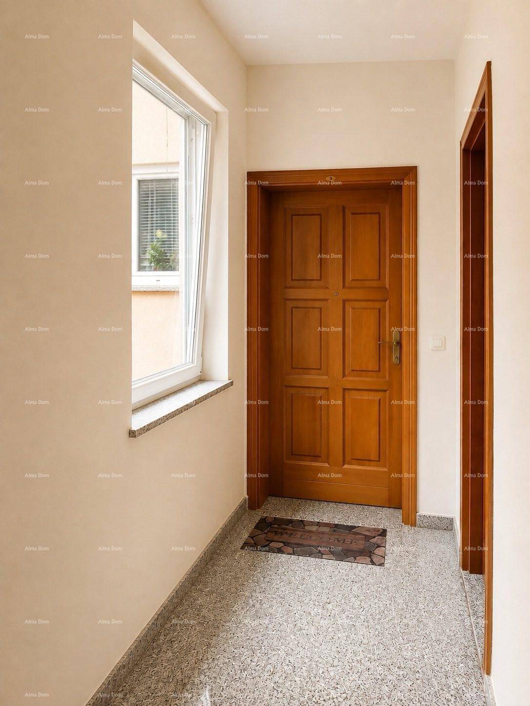 Heller Eingangsbereich mit Fenster, Holztür und gefliestem Boden.