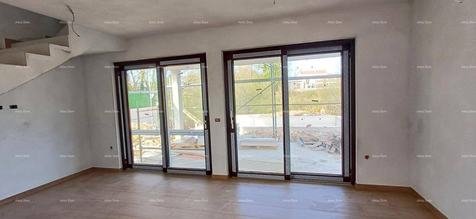 Geräumiger Wohnbereich im Rohbau mit Treppe und Zugang zum Außenbereich.