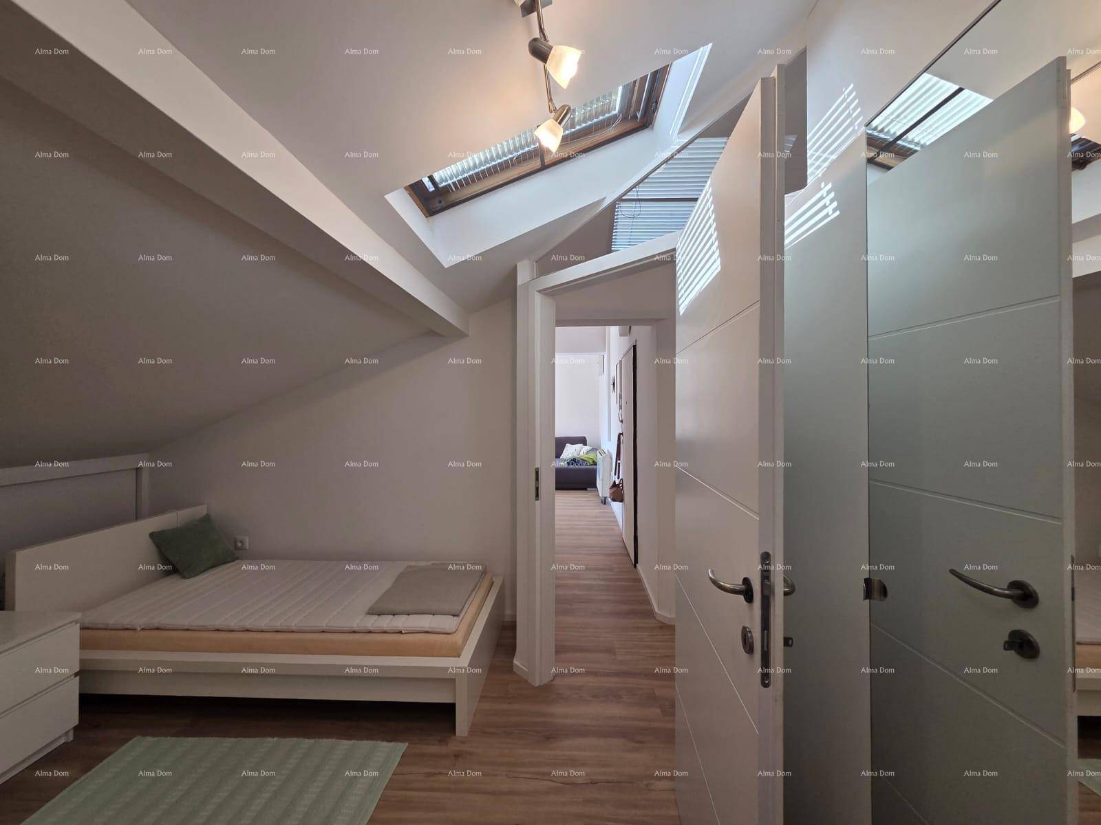 Helles Schlafzimmer im Dachgeschoss mit Holzboden und Dachfenstern, die viel natürliches Licht hereinlassen.
