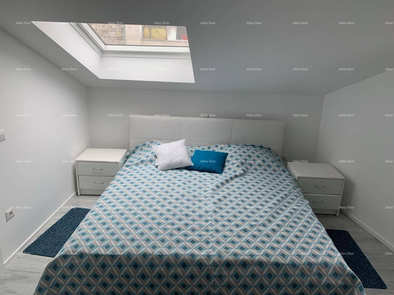 Gemütliches Schlafzimmer mit großem Doppelbett, Nachttischen und einem Dachfenster.